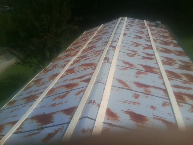 Rusted metal roof panels with new wood purlins before replacement — Storm Damage Roof Repair in Helix by Roofing Brothers
