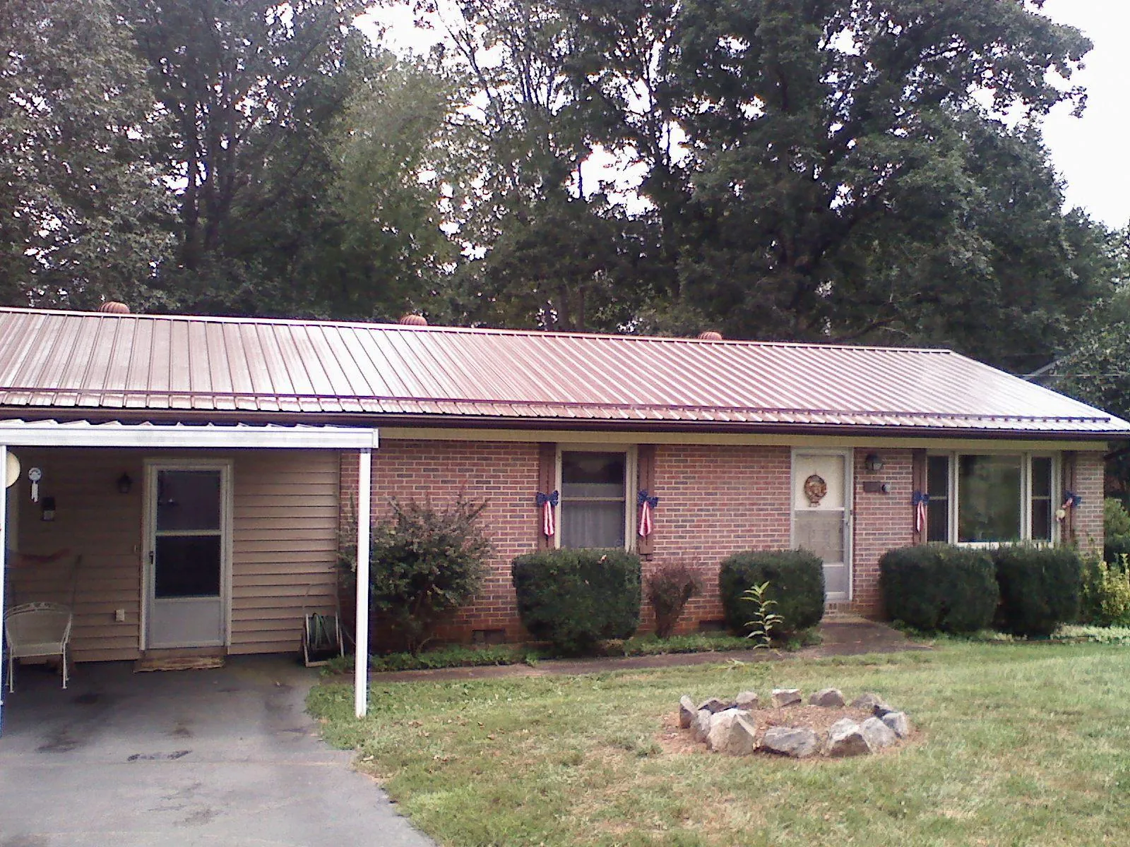 Bronze metal roof and carport on a brick ranch home — Roof Repair work by our crew in Helix
