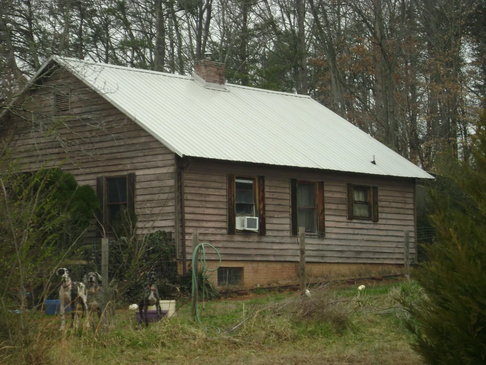 White metal roof on an old wood sided farmhouse, from a Metal Roof Installation job in Helix